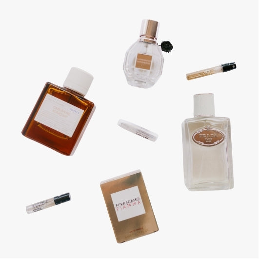 flat lay of fragrance beauty products for The Beauty Exchange, including sprays roll on and men and women's perfumes on a light neutral background